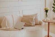 A serene minimalist living space with a laptop and flowers, perfect for remote work.