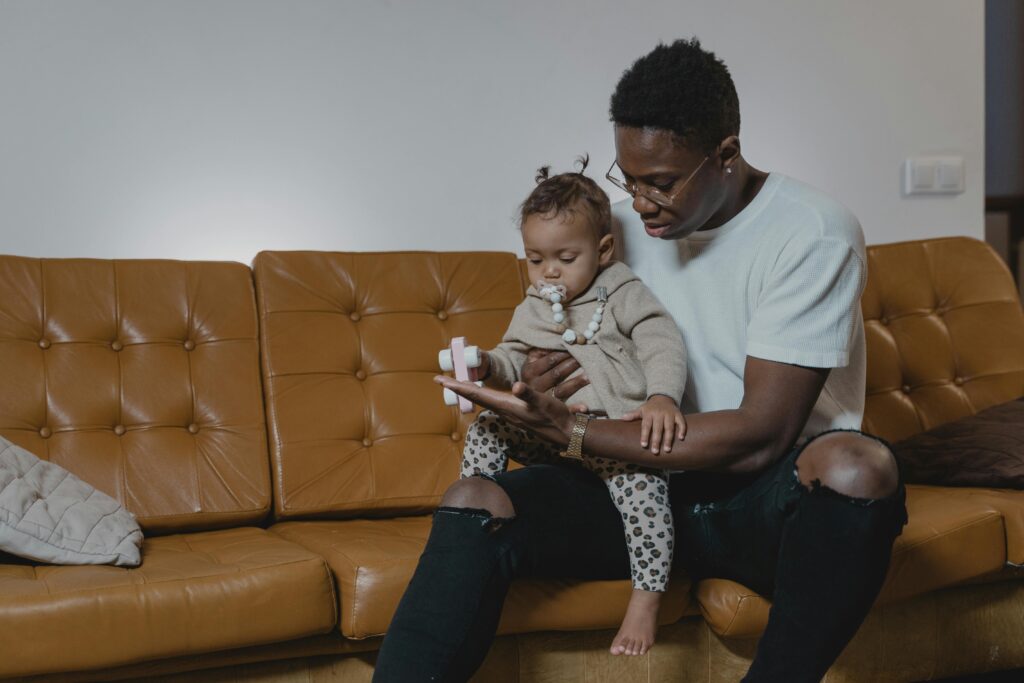 pexels photo 6321624 6321624 A father lovingly holds his baby on a leather sofa. Cozy indoor setting captures family bonding.